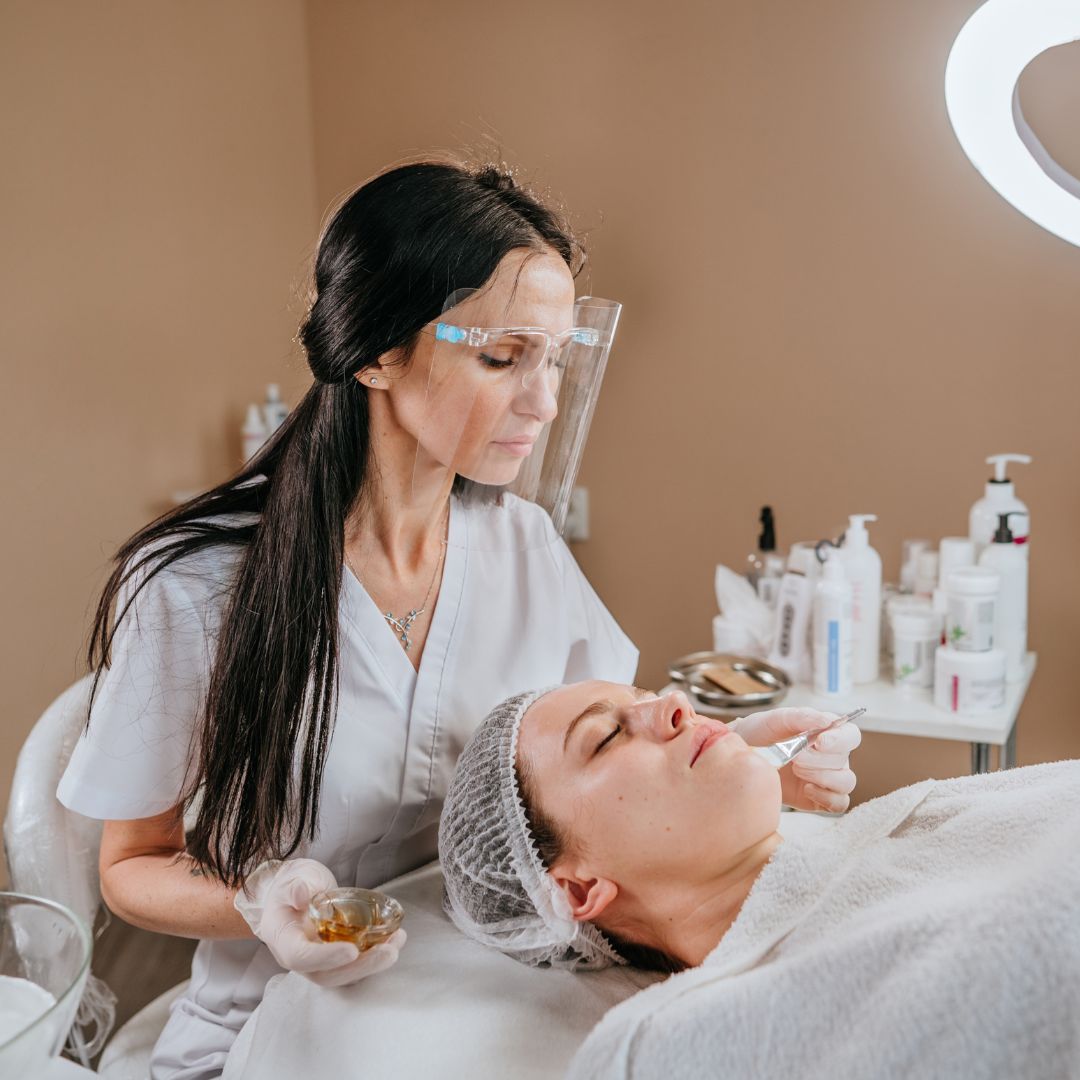 Esthetician wearing mask working with client