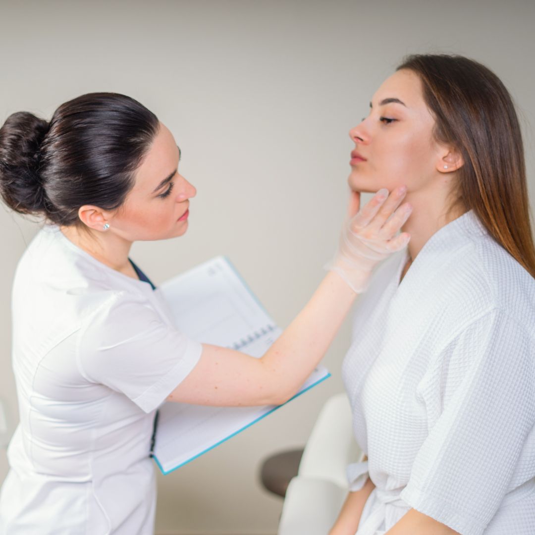 woman wearing gloves touches to examine patient's face