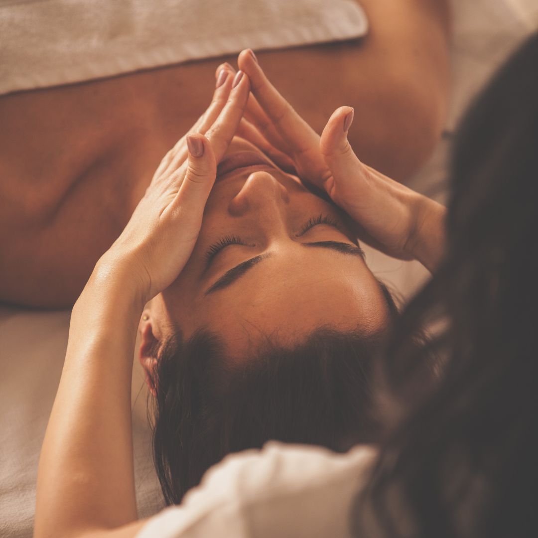 esthetician rubs hands over face of client 