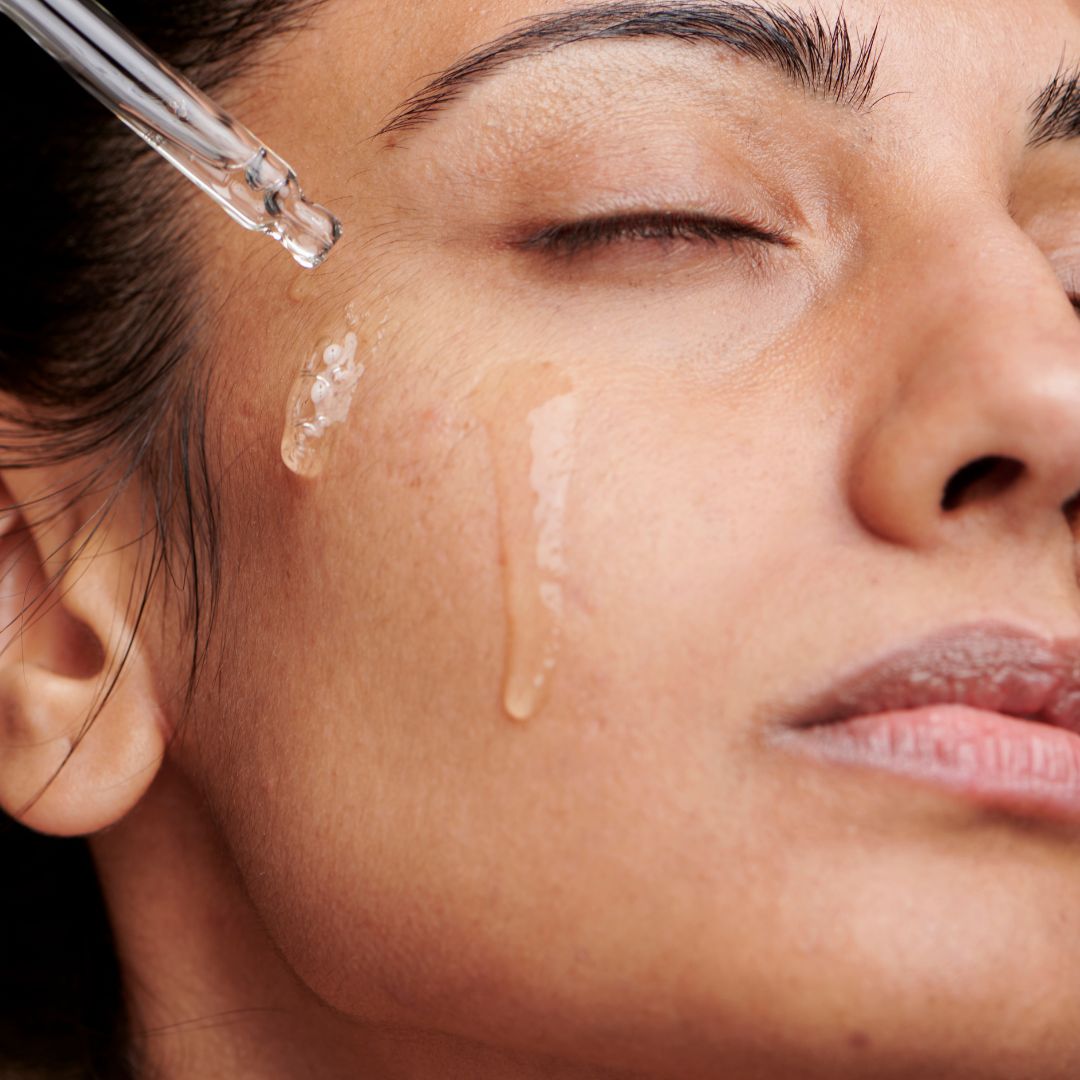 woman putting a serum on her face