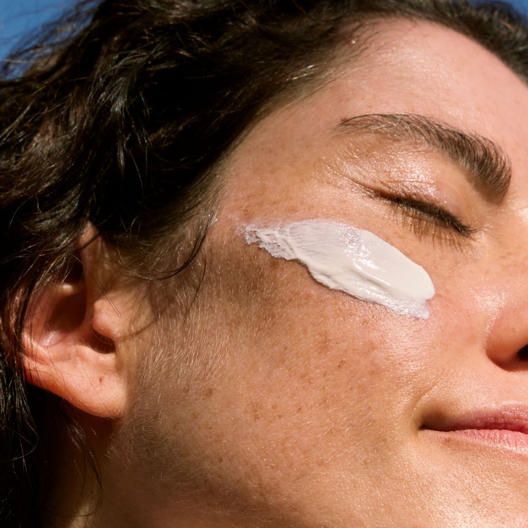 img of a woman putting on sunscreen